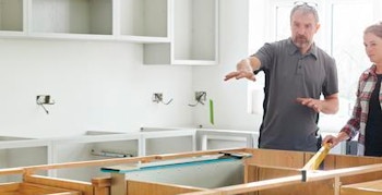 Home Builder and Trade Contractor Home builder and trade contractor reviewing the layout of kitchen cabinets